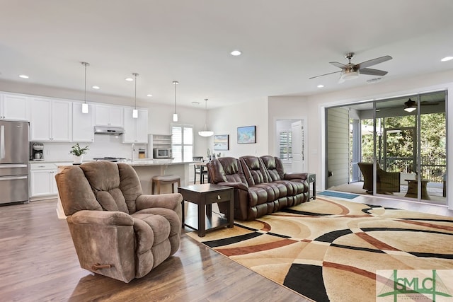 living room featuring light hardwood / wood-style flooring and ceiling fan