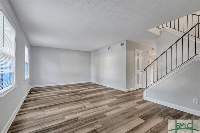 spare room with hardwood / wood-style flooring and a textured ceiling