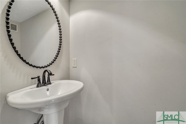 bathroom with a textured ceiling and sink