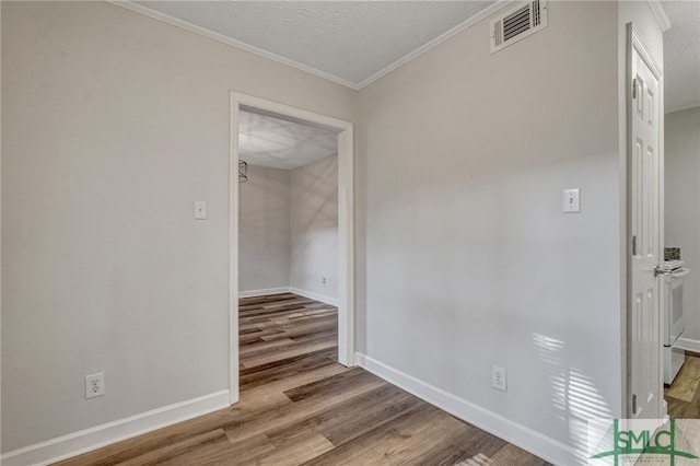 hallway featuring a textured ceiling, ornamental molding, and light wood-type flooring