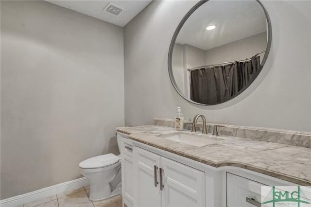 bathroom featuring vanity, toilet, and tile patterned floors