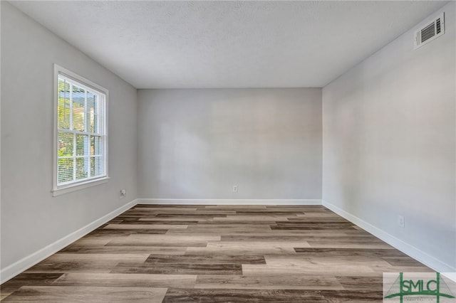 empty room featuring light hardwood / wood-style flooring and a textured ceiling