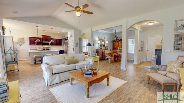 living room featuring ceiling fan with notable chandelier, light hardwood / wood-style floors, crown molding, and lofted ceiling