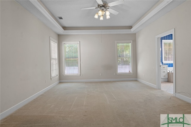 carpeted spare room with ceiling fan, a textured ceiling, and a tray ceiling