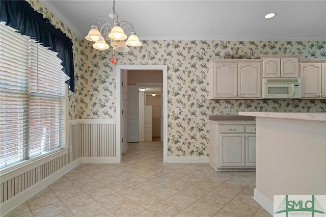 kitchen featuring wallpapered walls, a chandelier, white microwave, light countertops, and ornamental molding