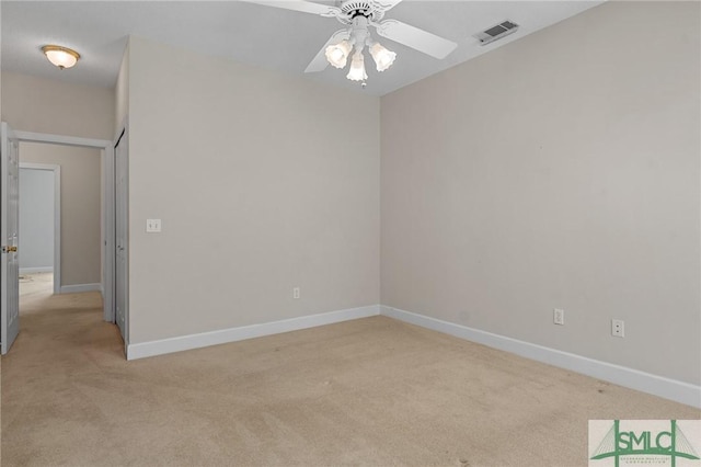 empty room with ceiling fan, visible vents, baseboards, and light carpet