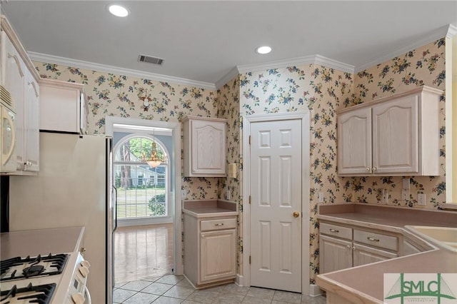 kitchen featuring gas range gas stove, visible vents, wallpapered walls, crown molding, and light countertops