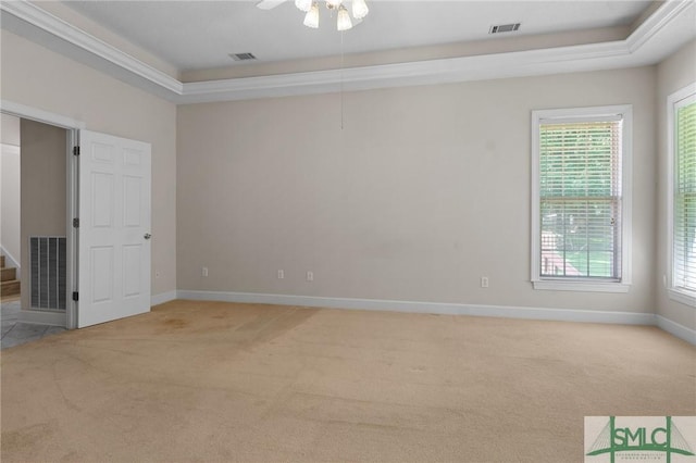 unfurnished room featuring a raised ceiling, visible vents, and light colored carpet