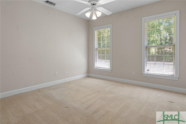 unfurnished room with baseboards, visible vents, and a healthy amount of sunlight