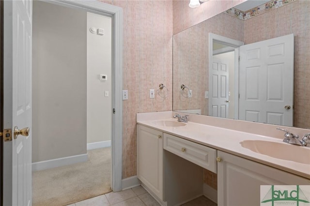 bathroom featuring double vanity, tile patterned floors, baseboards, and a sink