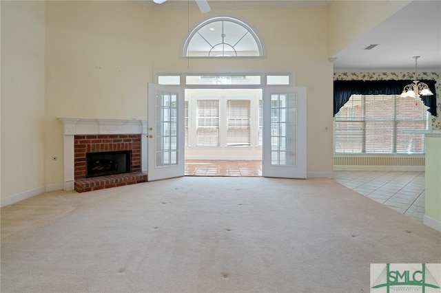 unfurnished living room featuring a wealth of natural light, a high ceiling, light carpet, and a fireplace