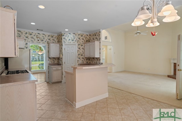 kitchen with light carpet, kitchen peninsula, ornamental molding, pendant lighting, and ceiling fan with notable chandelier