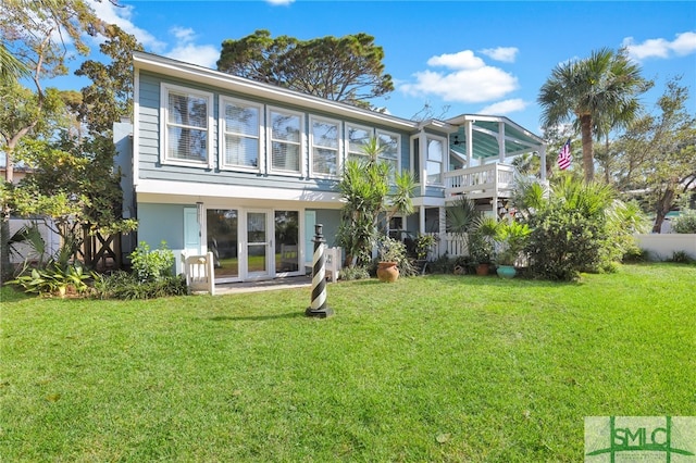 back of property with french doors and a lawn