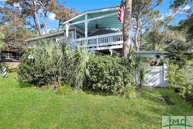 rear view of house with a lawn and a ceiling fan