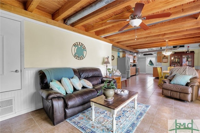 living room featuring a ceiling fan, light tile patterned floors, beamed ceiling, wooden ceiling, and visible vents