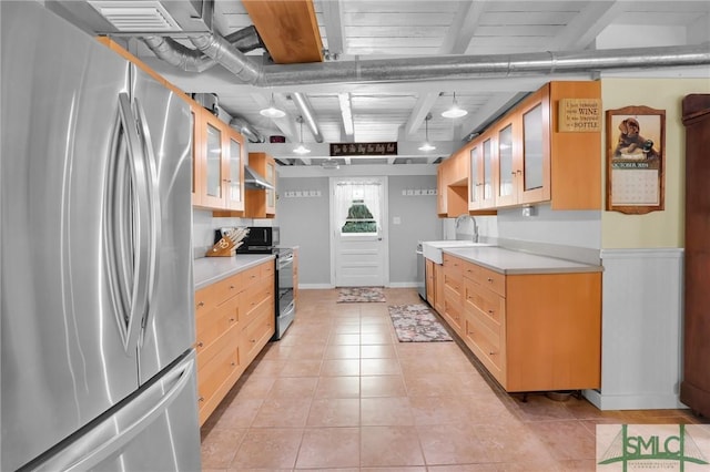 kitchen featuring light countertops, light brown cabinets, light tile patterned floors, a sink, and appliances with stainless steel finishes