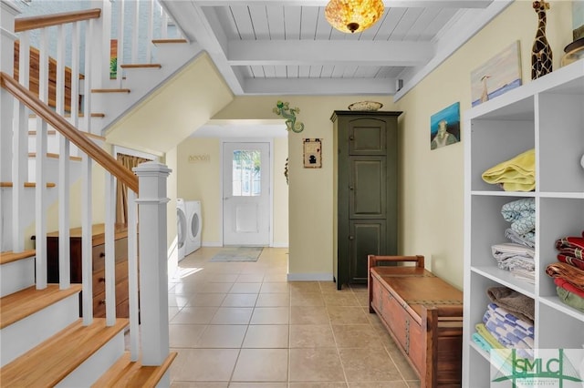 interior space with independent washer and dryer, beam ceiling, stairs, and light tile patterned floors