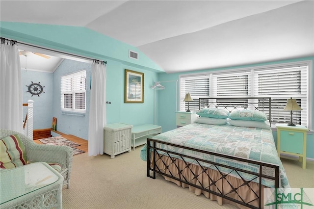 bedroom with lofted ceiling, light carpet, and visible vents