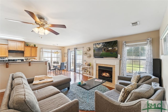 living room with light hardwood / wood-style flooring, a fireplace, and ceiling fan