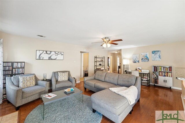 living room with dark wood-type flooring and ceiling fan