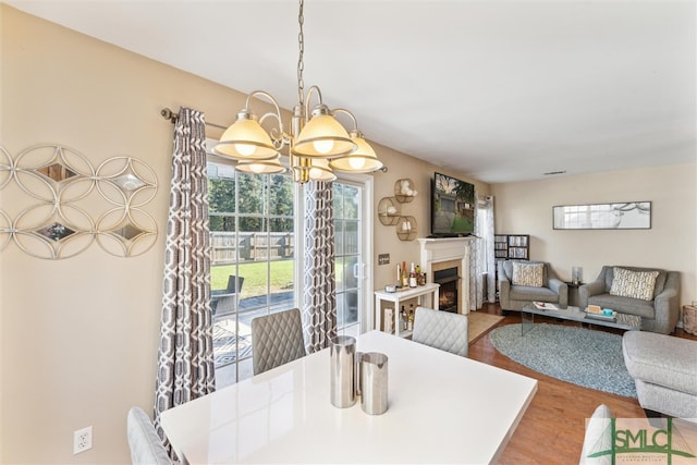 dining space with an inviting chandelier and hardwood / wood-style flooring