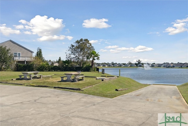 view of community featuring a water view and a yard