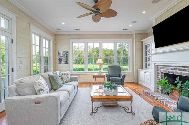 living room with light hardwood / wood-style flooring, a healthy amount of sunlight, and ceiling fan