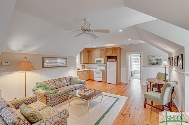 living room with ceiling fan, lofted ceiling, and light hardwood / wood-style flooring