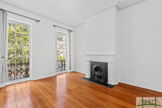 117 W Gaston St, Savannah, GA 31401 - unfurnished living room with a fireplace with flush hearth, baseboards, ornamental molding, and hardwood / wood-style floors