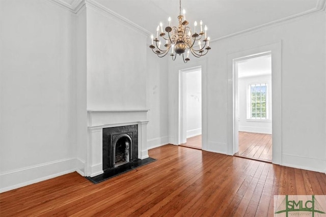 117 W Gaston St, Savannah, GA 31401 - unfurnished living room with crown molding, a fireplace, wood-type flooring, a chandelier, and baseboards