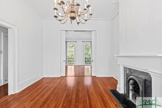 117 W Gaston St, Savannah, GA 31401 - unfurnished living room featuring a high end fireplace, wood finished floors, a notable chandelier, and ornamental molding