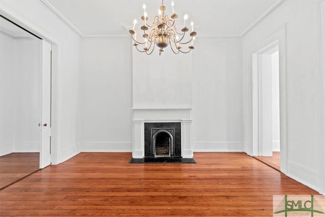 117 W Gaston St, Savannah, GA 31401 - unfurnished living room with an inviting chandelier, a fireplace with flush hearth, crown molding, and wood finished floors