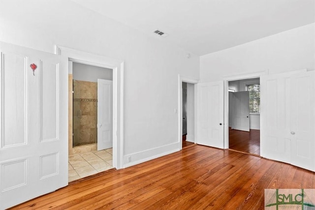 117 W Gaston St, Savannah, GA 31401 - unfurnished bedroom featuring connected bathroom, visible vents, and hardwood / wood-style flooring