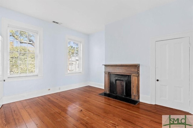 117 W Gaston St, Savannah, GA 31401 - unfurnished living room featuring visible vents, baseboards, a fireplace, and hardwood / wood-style flooring