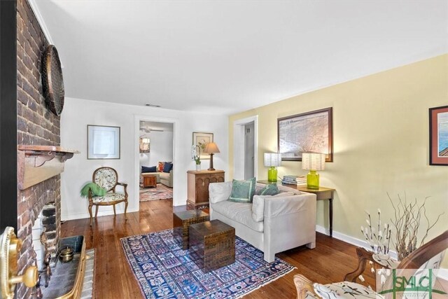 117 W Gaston St, Savannah, GA 31401 - living room featuring baseboards, a ceiling fan, a brick fireplace, and wood finished floors