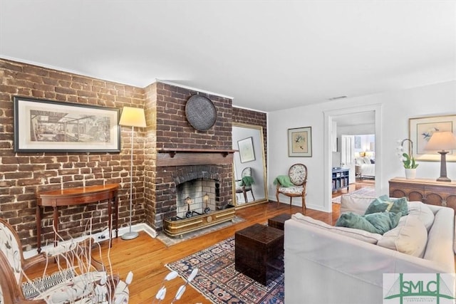 117 W Gaston St, Savannah, GA 31401 - living area with a brick fireplace, wood finished floors, and visible vents