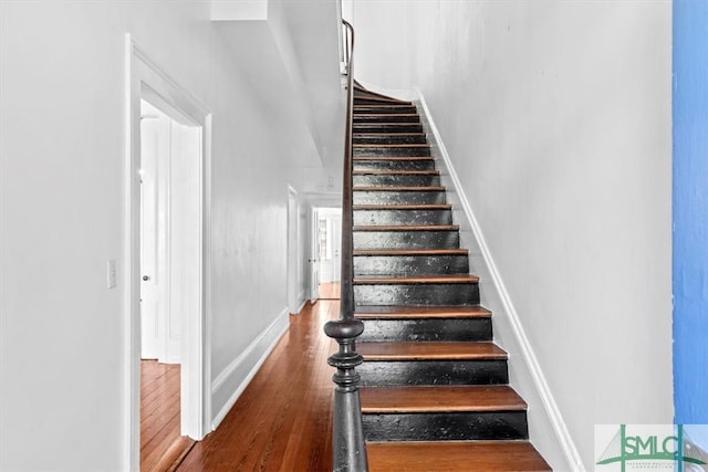 staircase with hardwood / wood-style flooring