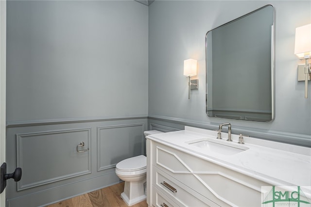 bathroom featuring vanity, toilet, and hardwood / wood-style floors