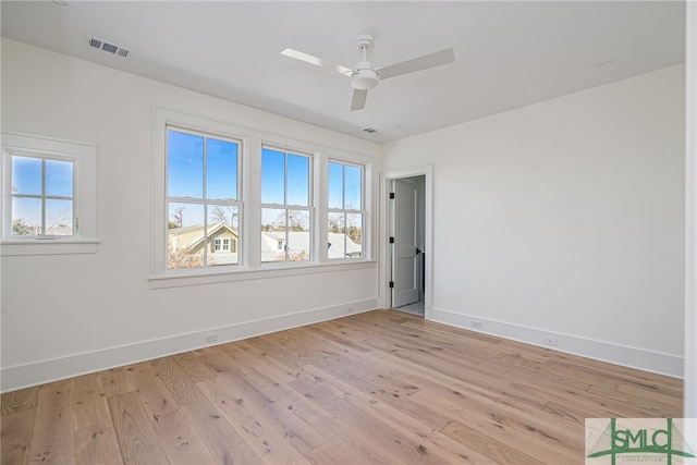 unfurnished room with light wood finished floors, plenty of natural light, visible vents, and baseboards