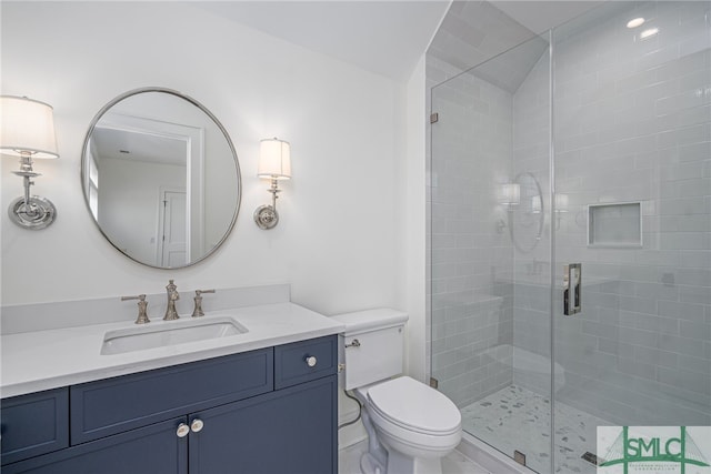 bathroom with walk in shower, vanity, and toilet