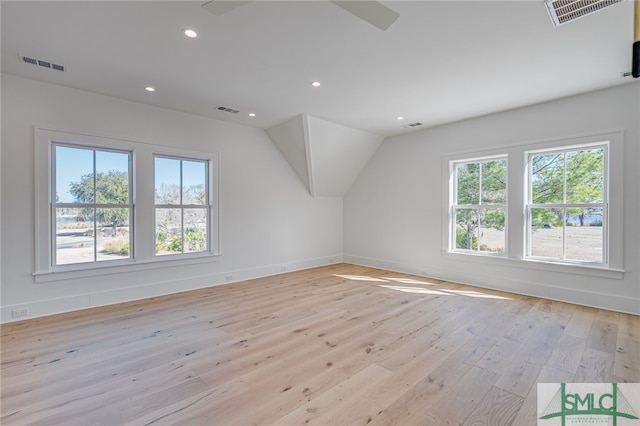 bonus room with vaulted ceiling and light wood-type flooring