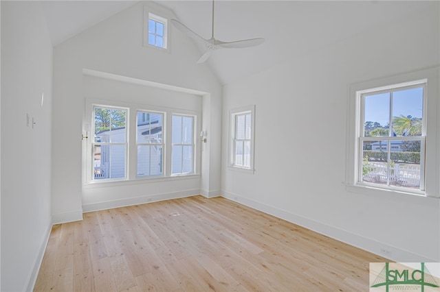 empty room featuring a wealth of natural light, light hardwood / wood-style flooring, high vaulted ceiling, and ceiling fan