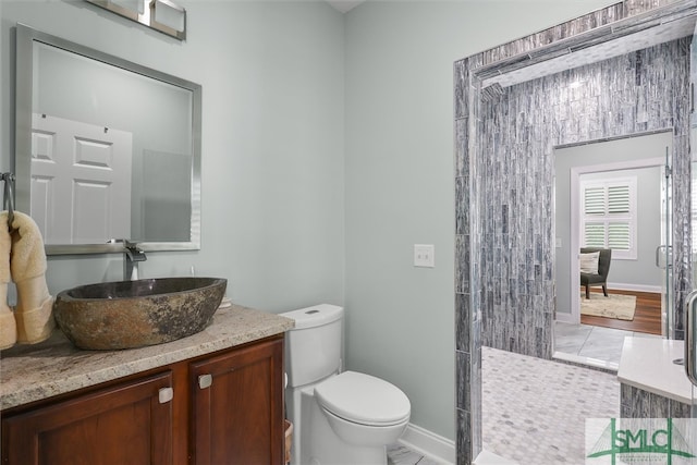 bathroom with vanity, toilet, walk in shower, and hardwood / wood-style floors