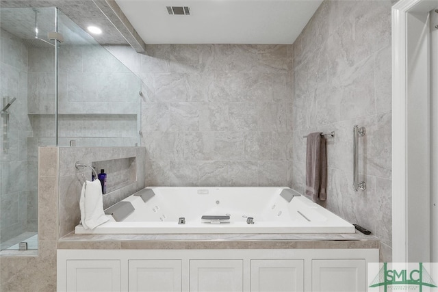 bathroom featuring tile walls and separate shower and tub