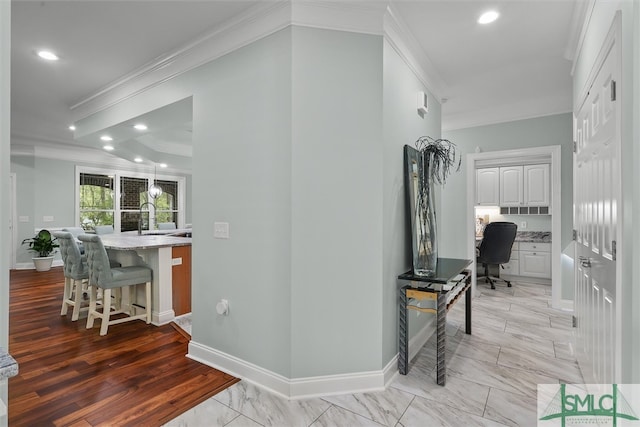 corridor featuring sink, crown molding, and light hardwood / wood-style flooring