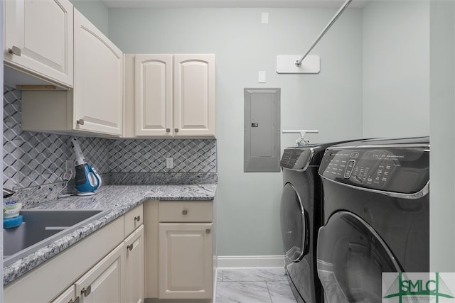 washroom featuring sink, washing machine and dryer, electric panel, and cabinets