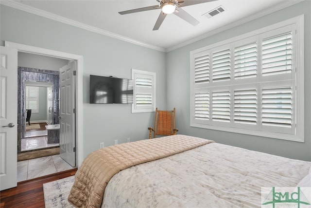 bedroom featuring ornamental molding, dark wood-type flooring, ceiling fan, and ensuite bath