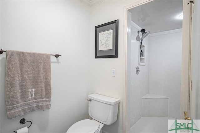 bathroom featuring toilet, ornamental molding, and a shower