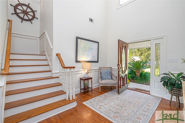 foyer entrance featuring hardwood / wood-style flooring and a towering ceiling