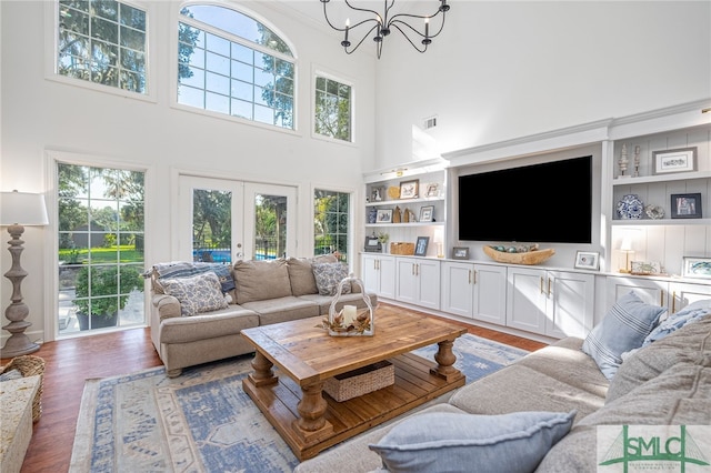 living room featuring built in features, a healthy amount of sunlight, and dark hardwood / wood-style flooring